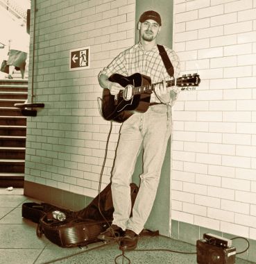 Musician in the subway, woman exiting.