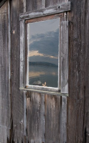 Landscape reflected in the window of this old cabin